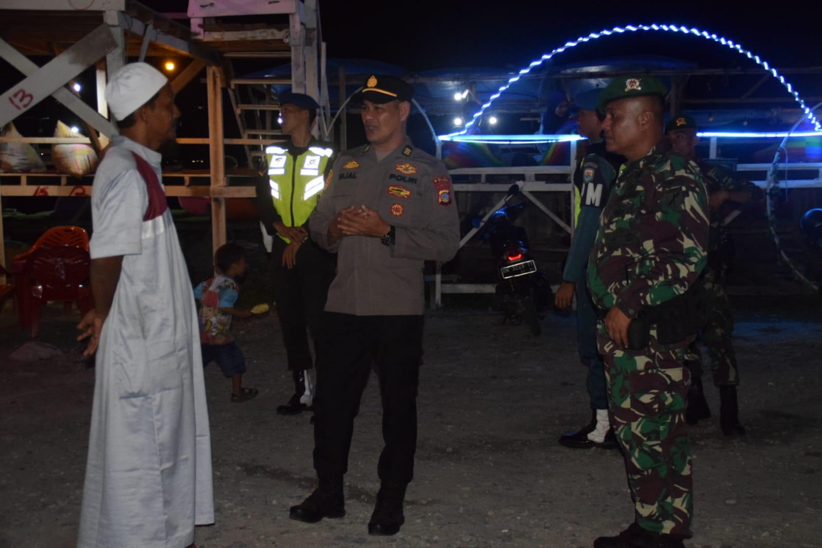 Petugas gabungan TNI-Polri saat berbincang-bincang dengan salahsatu warga di Pantai Talise, Kota Palu, Sabtu (20/5) malam. Foto : Dok Humas Polresta Palu